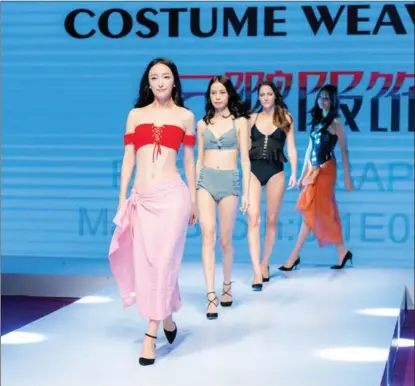  ?? PROVIDED TO CHINA DAILY ?? Models wearing swimsuits produced at a factory in Jinjiang, a county-level city in Fujian province, walk down the catwalk.