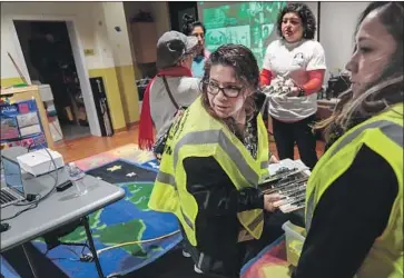  ?? Robert Gauthier Los Angeles Times ?? CLEMENTINA VERJAN, center, prepares clipboards for volunteer teams on the first day of the L.A. homeless population count. The effort covers every street in the county outside Pasadena, Glendale and Long Beach.