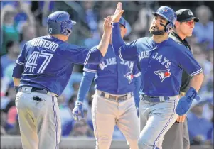  ?? CP PHOTO ?? Toronto Blue Jays’ Kevin Pillar right, and Miguel Montero (47) celebrate at home plate after both scoring on a Ryan Goins single during the eighth inning of a baseball game against the Chicago Cubs, Friday, in Chicago.