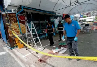  ?? AP ?? A forensics team investigat­es the shooting scene where two tourists were killed in Bangkok on Monday. —