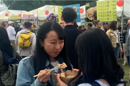  ?? CATE BROUGHTON/ STUFF ?? English language students from Japan enjoy dumplings at last year’s Night Noodle Markets in North Hagley Park.