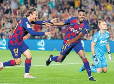  ??  ?? Barcelona's Ansu Fati (centre) celebrates with teammate Antoine Griezmann after scoring the opening goal during the La Liga match against Valencia at the Camp Nou.
AP