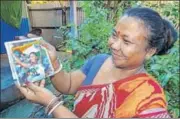  ?? PTI ?? Swapna’s mother ■Basana Barman, holds up a picture of her daughter at the Games. Basana often did double shifts plucking leaves at a tea garden, after her husband suffered a stroke, to provide for him and their four children.