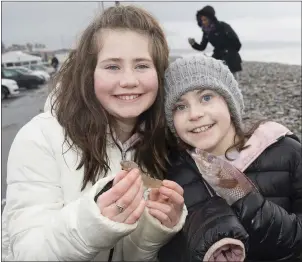  ??  ?? Robyn and Hannah Lynch with an eel and a fish washed up on shore.