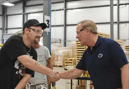  ?? Daniel Moore/Post-Gazette ?? U.S. Rep. John Joyce, R-Blair, right, shakes the hand of an employee at Jamison, a manufactur­er of garage doors, based near Waynesboro, Franklin County, on Tuesday. The visit was part of a multiday tour of his large district, where he encouraged people to get vaccinated but remained staunchly against vaccine mandates.