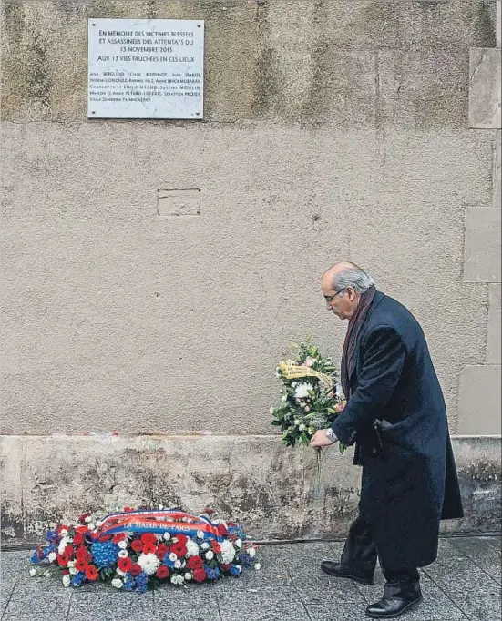  ?? POOL / REUTERS ?? Un hombre deposita un ramo de flores bajo la placa inaugurada en las proximidad­es de los cafés Le Carillon y Le Petit Cambodge