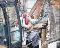  ?? GLEN WHIFFEN/THE TELEGRAM ?? The excavator operator paused during demolition Tuesday to retrieve a finial — a distinctiv­e ornament that was attached to the top of the manor’s