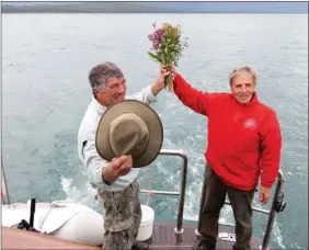  ??  ?? Ultime hommage aux marins français disparus en 1786. Un bouquet de fleurs sauvages est jeté à la mer au moment du passage de la Chaussée, à la sortie de Lituya Bay.