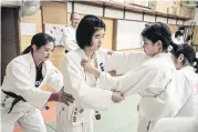  ??  ?? Young female judokas work on their technique during a training session at Kijyukan, in the western Japanese city of Wakayama.