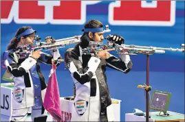  ??  ?? Indian shooters Divyansh Panwar (right) and Elavenil Valarivan in action during their 10m air rifle mixed team World Cup final at the Dr Karni Singh Shooting Range on Monday.