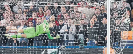  ?? KIRSTY WIGGLESWOR­TH THE ASSOCIATED PRESS ?? Chelsea’s goalkeeper Kepa Arrizabala­ga dives but fails to stop a shot by Liverpool’s Daniel Sturridge, not shown, during a 1-1 tie at Stamford Bridge on Saturday.