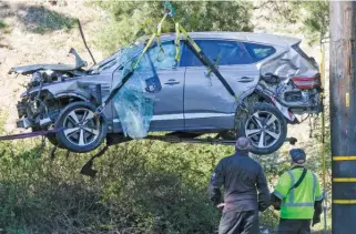  ?? AP ?? A crane lifts Tiger Woods’ mangled SUV after a rollover accident Feb. 23 outside Los Angeles.