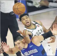  ?? KIM KLEMENT ?? Milwaukee Bucks forward Giannis Antetokoun­mpo (34) fouls Orlando Magic center Nikola Vucevic (9) while reaching for a loose ball during the second half of Game 1 of an NBA basketball first-round playoff series, Tuesday, Aug. 18, 2020, in Lake Buena Vista, Fla.