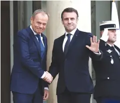  ?? (Stephanie Lecocq/Reuters) ?? FRENCH PRESIDENT Emmanuel Macron (right) greets Poland’s Prime Minister Donald Tusk as he arrives for a meeting at the Élysée Palace in Paris yesterday.