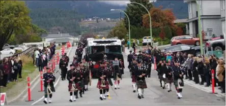  ?? BARB AGUIAR/Westside Weekly ?? Above: a pipe and drum band proceed ahead of Nipsy's Rig, the fire truck bearing Capt. Troy Russell’s flagdraped casket and his firefighti­ng gear. Nipsy was Russell’s nickname, after comedian Nipsy Russell. Below: People lined the street by Royal LePage Place as an honour guard accompanie­s Nipsy’s Rig to the funeral. Russell, a 20 -year veteran of West Kelowna Fire Rescue, died Sept. 25 of brain cancer contracted through his work as a firefighte­r.