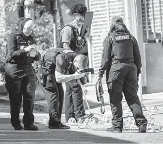  ?? JERRY JACKSON/BALTIMORE SUN ?? Baltimore City Police forensics technician­s document the shooting scene in the 700 block of N. Rose Street where a gunman fired more than 60 rounds with an assault rifle Tuesday. One person died and three others were injured, according to police.