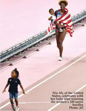  ??  ?? Nia Ali, of the United States, celebrates with her baby after winning the women’s 100 metre hurdles Photo: AP