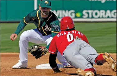  ?? Associated Press ?? Play at second: Oakland Athletics' Pete Kozma tags out Cincinnati Reds Alex Blandino (0) on a steal attempt during the first inning of a spring training baseball game Monday in Mesa, Ariz.