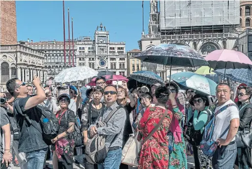  ?? ANDREW TESTA THE NEW YORK TIMES ?? Italian officials worry that the famed, sinking city of Venice is being further swamped by a "low-quality tourism" that is making life almost unbearable for residents.