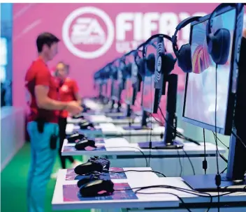  ?? FOTO: DPA ?? An die Konsolen. Fertig. Los: An einem Stand von EA Sports kann das Videospiel Fifa 19 ausprobier­t werden.