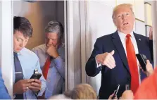  ?? SUSAN WALSH/ASSOCIATED PRESS ?? White House deputy press secretary Hogan Gidley, left, and deputy chief of staff for communicat­ions Bill Shine listen as President Donald Trump talks to reporters on Air Force One on Friday.