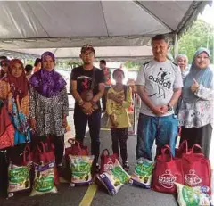  ??  ?? PENERIMA sumbangan bersama barang keperluan masing-masing.