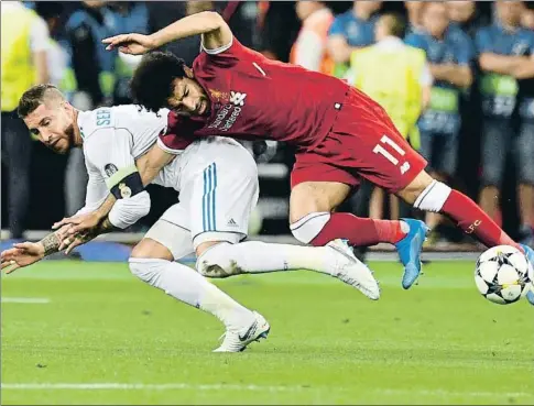  ?? GENYA SAVILOV / AFP ?? Sergio Ramos lesionó al delantero del Liverpool Mohamed Salah con este agarrón, el sábado en Kíev