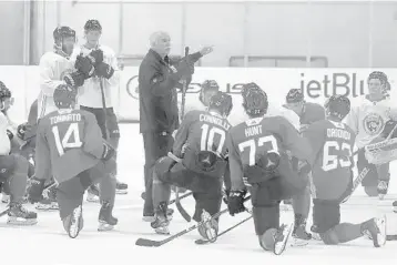  ?? LYNNE SLADKY/AP ?? Panthers coach Joel Quennevill­e, center, talks with his players on July 14 in Coral Springs.