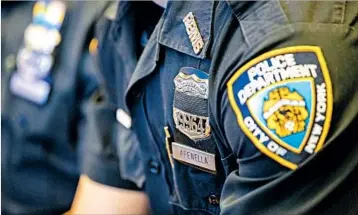  ?? MARY ALTAFFER/AP ?? New York City police officers wear mourning bands over their badges in honor of slain officer Miosotis Familia.