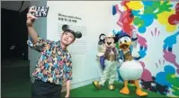  ?? PROVIDED TO CHINA DAILY ?? A visitor takes a selfie with Mickey Mouse and Donald Duck at the Mickey: The True Original & Ever Curious exhibition in Shanghai earlier this year.