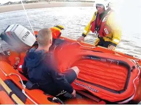  ??  ?? Saved: A lifeboat crew member returns the beachgoer to shore