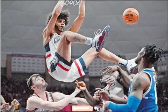  ?? JESSICA HILL/AP PHOTO ?? UConn’s Andre Jackson Jr. dunks over teammates Alex Karaban, left, and Adama Sanogo during the second half of Saturday’s 64-55 Big East victory over Seton Hall at Gampel Pavilion in Storrs.