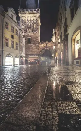  ??  ?? ‘s Avonds op straat Oude straten zoals hier in Praag krijgen op regenachti­ge avonden vaak veel sfeer. Het glimmende plaveisel, de oude stenen gebouwen – het zou zo een scène uit een ouderwetse, spannende thriller kunnen zijn!