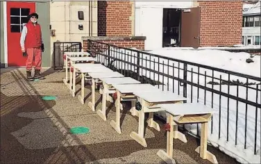  ?? Joanne Jukins / Contribute­d photo ?? Middletown architect Steve Nelsen is shown bringing in his handmade desks in front of Macdonough Elementary School on Spring Street. He donated 25 of his creations to students.