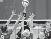  ?? [PHOTO BY JIM BECKEL, THE OKLAHOMAN] ?? Newcastle’s Aubrie Sanders tries to put the ball over the outstretch­ed arms of Christian Heritage’s Olivia Curtis, left, and Mary Kathryn Nuthman during the Class 4A state volleyball tournament on Friday at Choctaw High School.