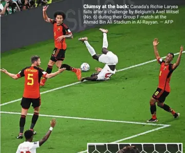  ?? — AFP ?? Clumsy at the back: Canada’s richie Laryea falls after a challenge by belgium’s axel Witsel (No. 6) during their Group F match at the ahmad bin ali Stadium in al-rayyan.