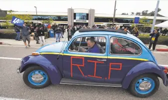  ?? Denis Poroy / Associated Press ?? Tom Sutton pulls his Volkswagen “Bolt Bug” out of the San Diego Chargers’ headquarte­rs driveway Thursday after the team announced that it will move to Los Angeles.