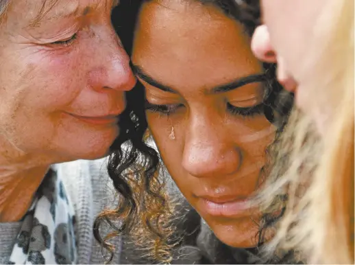  ??  ?? Christchur­ch residents comfort each other after leaving flowers in tribute to victims of the mosque massacre.