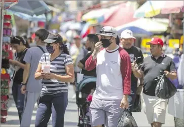  ?? Irfan Khan Los Angeles Times ?? L.A. COUNTY was recording 96 deaths a week for every 10 million residents, while the Bay Area’s rate was 56 deaths for every 10 million residents. Above, some shoppers mask up at bustling Santee Alley market in L.A.