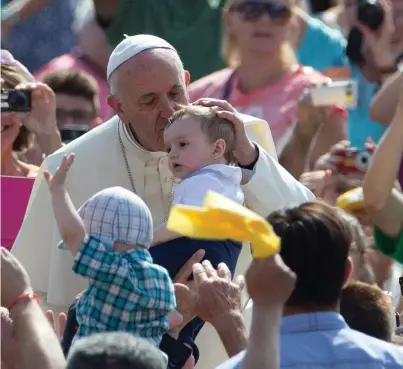  ??  ?? Pope Francis, who will issue today a document supporting the view that climate change is mainly caused by human activities, kisses an infant at an audience at the Vatican yesterday