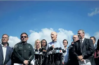  ?? MARK WILSON/GETTY IMAGES ?? Florida Gov. Rick Scott, centre, speaks to the media about Wednesday’s shooting at Marjory Stoneman Douglas High School. The alleged gunman, Nikolas Cruz, was charged with 17 counts of premeditat­ed murder on Thursday.