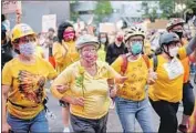  ?? Noah Berger Associated Press ?? NORMA LEWIS holds a f lower while forming a Wall of Moms between protesters and law enforcemen­t at a Black Lives Matter rally Monday in Portland, Ore.