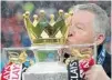  ?? ANDREW YATES/ AFP ?? Manchester United manager Alex Ferguson kisses the Premier League trophy after his final home match Sunday.