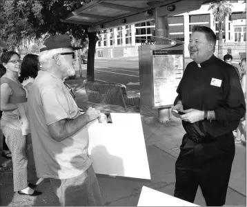  ?? PHOTOS BY HOWARD FISCHER/CAPITOL MEDIA SERVICES ?? THE REV. DAVID FELTEN DISCUSSES HIS OPPOSITION TO DILUTING the teaching of evolution with other protesters Monday ahead of a state Board of Education meeting to review the issue. The board took no action.