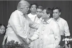  ?? Associated Press ?? President Donald Trump, left, shakes hands with Philippine­s President Rodrigo Duterte on Sunday at an ASEAN Summit dinner at the SMX Convention Center in Manila, Philippine­s. Trump is on a five-country trip through Asia, traveling to Japan, South...