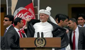  ?? AP ?? Afghan President Ashraf Ghani, centre, is pictured moments after several rockets were fired during his speech after he was sworn in.