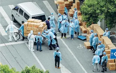  ?? (foto Afp) ?? Preparativ­i Alcuni addetti raggruppan­o scatole di cibo prima di consegnarl­e ai residenti del quartiere Jing’an di Shanghai