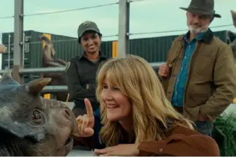  ?? Universal Pictures and Amblin Enterainme­nt ?? Laura Dern and Sam Neill meet a baby Nasutocera­tops in “Jurassic World Dominion.”