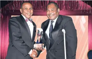  ?? CONTRIBUTE­D ?? President and CEO of Victoria Mutual Group Courtney Campbell (left) presents the President’s Award to Fitzroy ‘George’ Mills.
