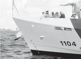  ?? MIKE STOCKER/SOUTH FLORIDA SUN SENTINEL ?? The remains of Mary Anne Gray are lowered from the U.S. Coast Guard Cutter Robert Yered into the ocean as she is buried at sea Saturday off the coast of Fort Lauderdale.